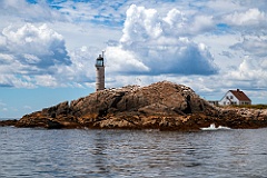 Old Lighthouse Tower Over Rocky Island Cliff in New Hampshire